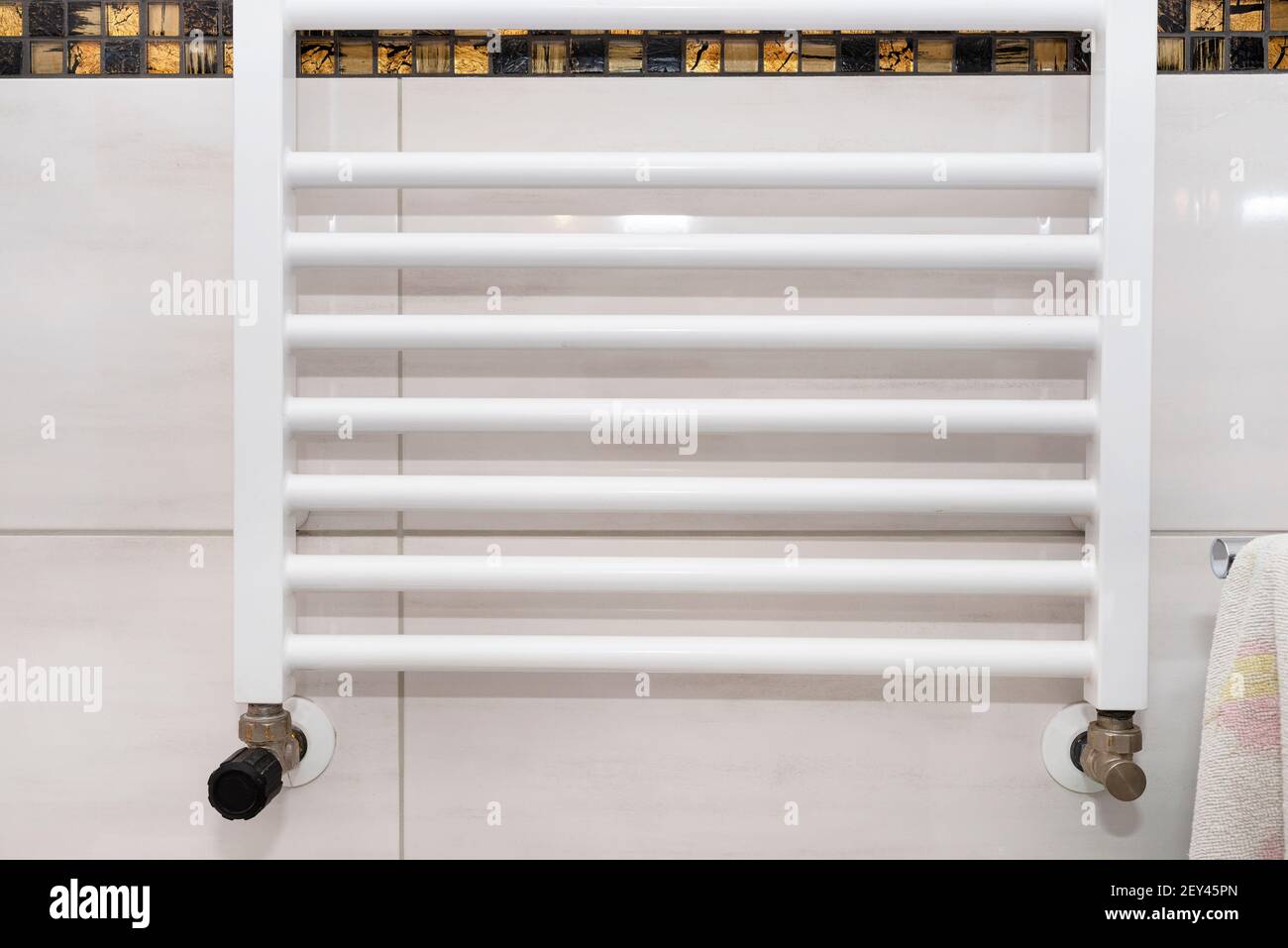 A modern heater attached to the wall with ceramic tiles in the bathroom