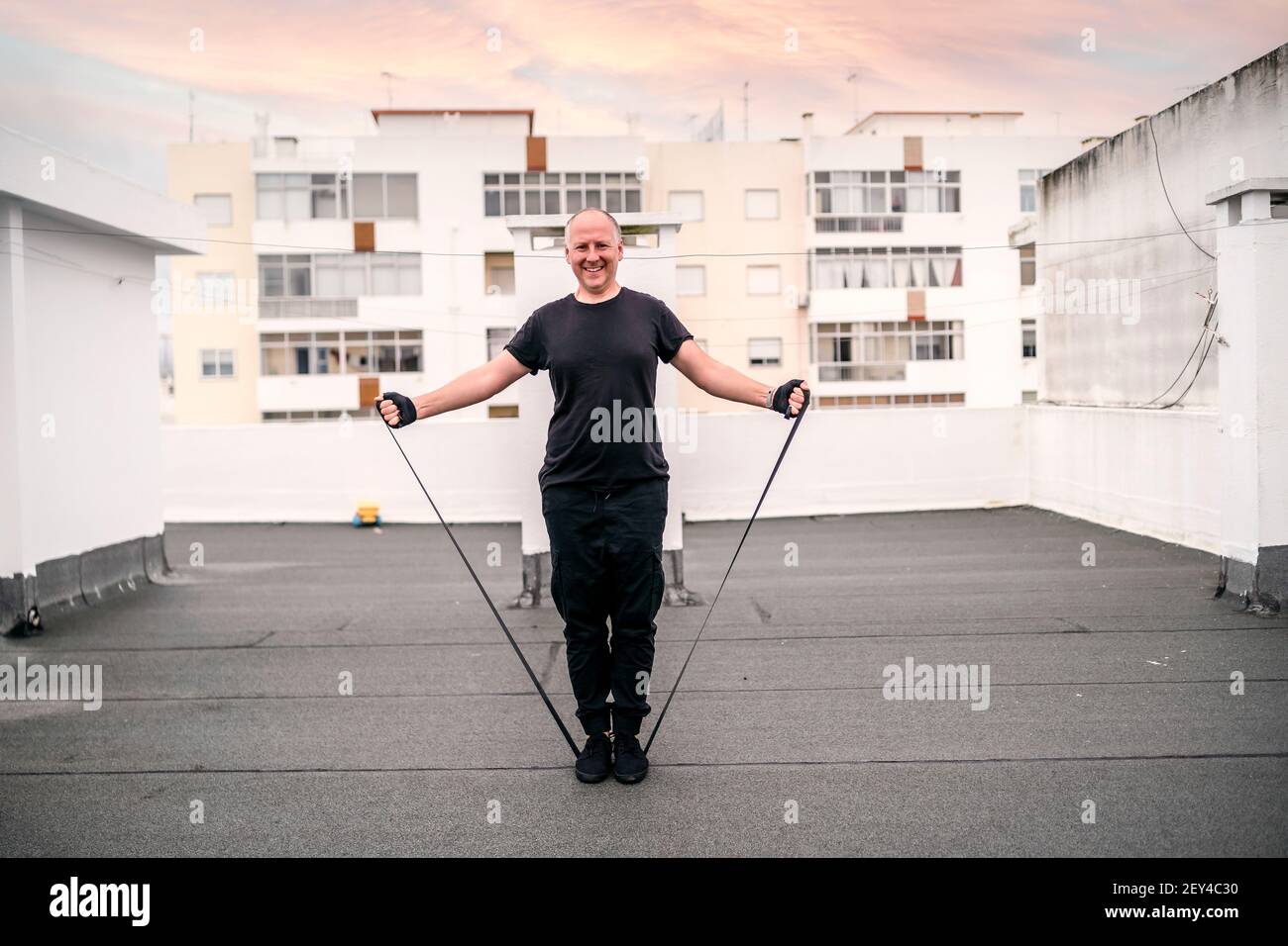 A man exercising with gum on the rooftop during self-confinement caused by pandemic Stock Photo