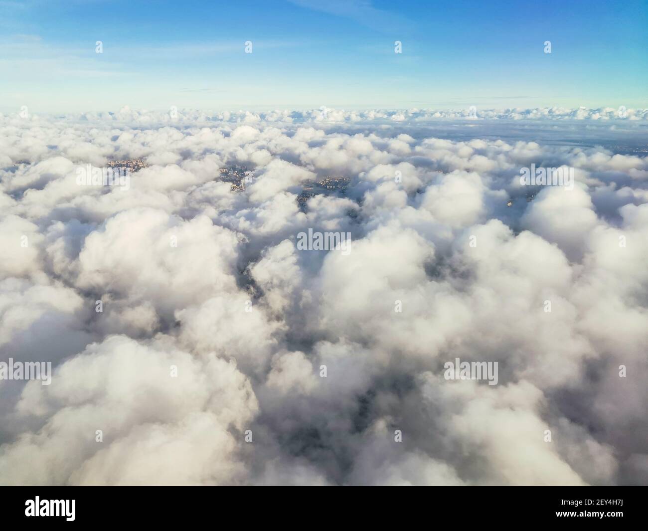 A beautiful view from the plane to white voluminous fluffy thunderclouds and the space of the stratosphere, top view. Beautiful natural sky background Stock Photo