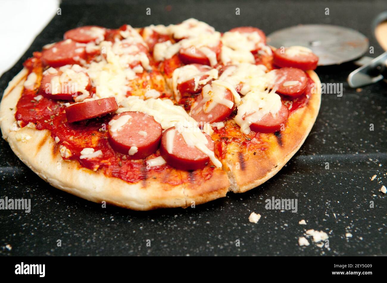 A closeup shot of a delicious mini-sized pizza with saussages Stock Photo