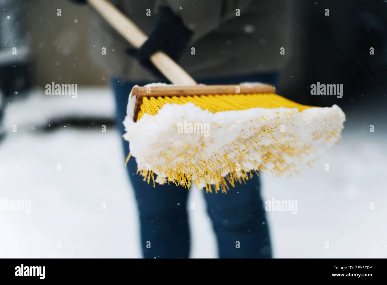 woman removes snow from his yard after a snowstorm, shoveling sn Stock Photo