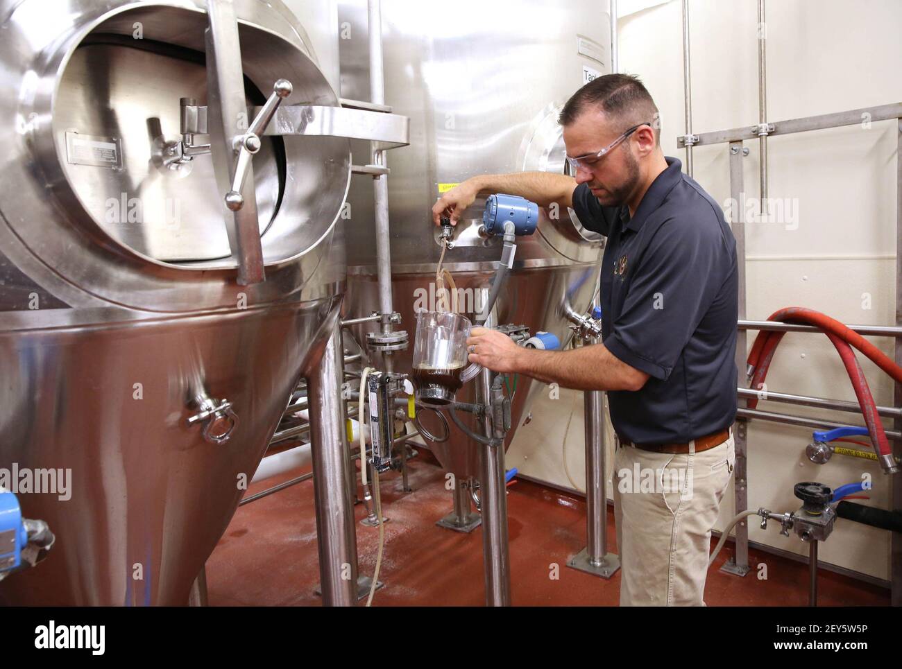 John Kimes, a MillerCoors pilot brewer, pours a sample of the Fred ...