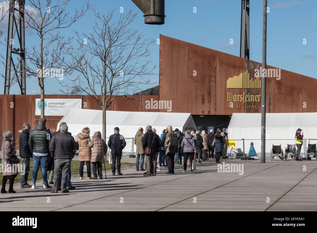 Dortmund, NRW, Germany, 05th Mar 2021. An orderly queue of people with appointments has formed outside the centre. Signage and directions to Impfzentrum Phoenix-West. Phoenix West, a former blast furnace and industrial site now housing culture and music venues is currently Dortmund's largest and busiest vaccination centre. The vaccination campaign in Germany is picking up momentum. Earlier this week, The German health ministry and vaccination commission STIKO cleared Astra Zeneca's vaccine for use in the over 65 age group. In addition, GP practices can start administering vaccinations soon. A Stock Photo