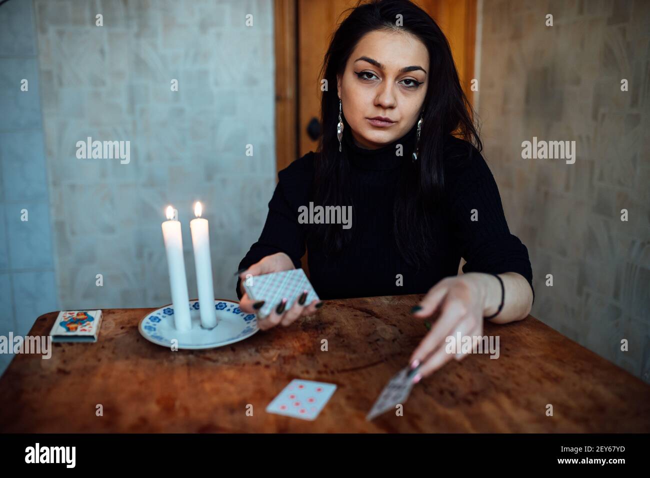 choose a card from the hands of a fortune teller. a woman tells fortunes during a magical ritual. belief in mysticism Stock Photo