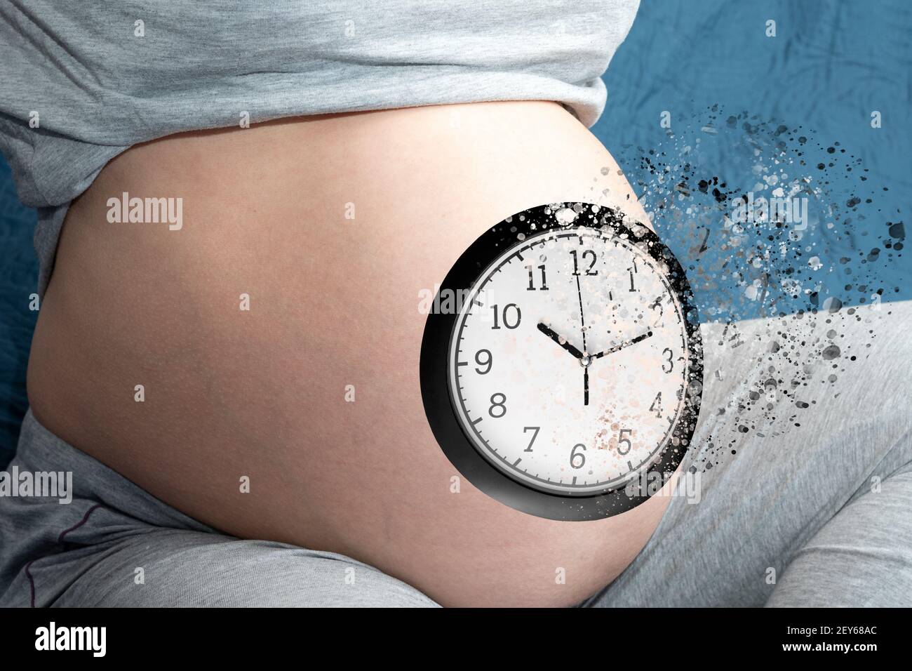 The concept of pregnancy. Pregnant woman belly with clock. The clock is destroyed as a symbol of the ending time, childbirth. A pregnant woman is expe Stock Photo