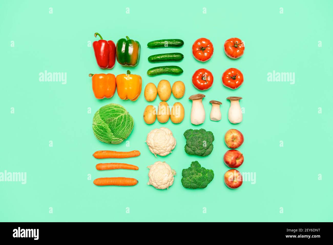 Creative layout with fresh vegetables and fruits, isolated on a green ...