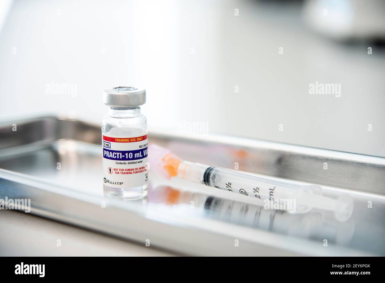 A vial and syringe on a metal tray in a doctor's office Stock Photo - Alamy