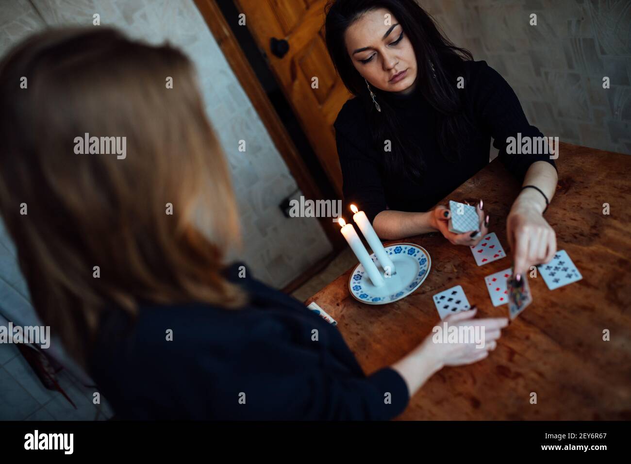 choose a card from the hands of a fortune teller. a woman tells fortunes during a magical ritual. belief in mysticism Stock Photo