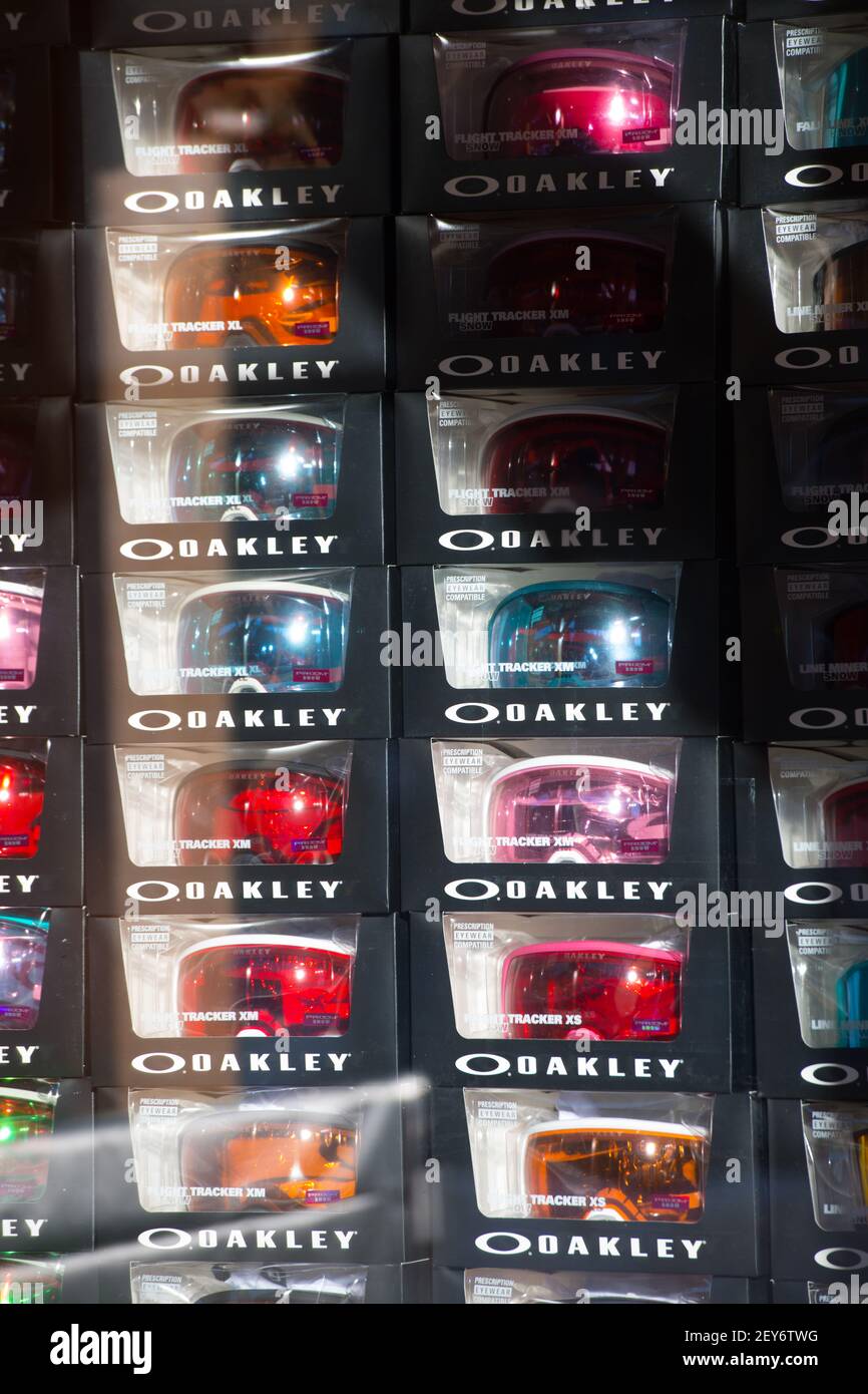 colorful oakley goggles in boxes in window of sports ski or snowboard shop or store at ski resort goggles reflecting in the sun shining through window Stock Photo