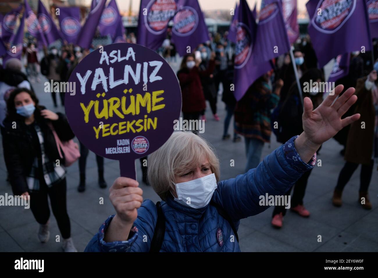 A demonstrator wearing a face mask to prevent the spread of the coronavirus disease (COVID-19), holds a placard reading 'You Will Never Walk Alone' during a protest against femicide and violence against women, in Istanbul, Turkey March 5, 2021. REUTERS/Murad Sezer Stock Photo