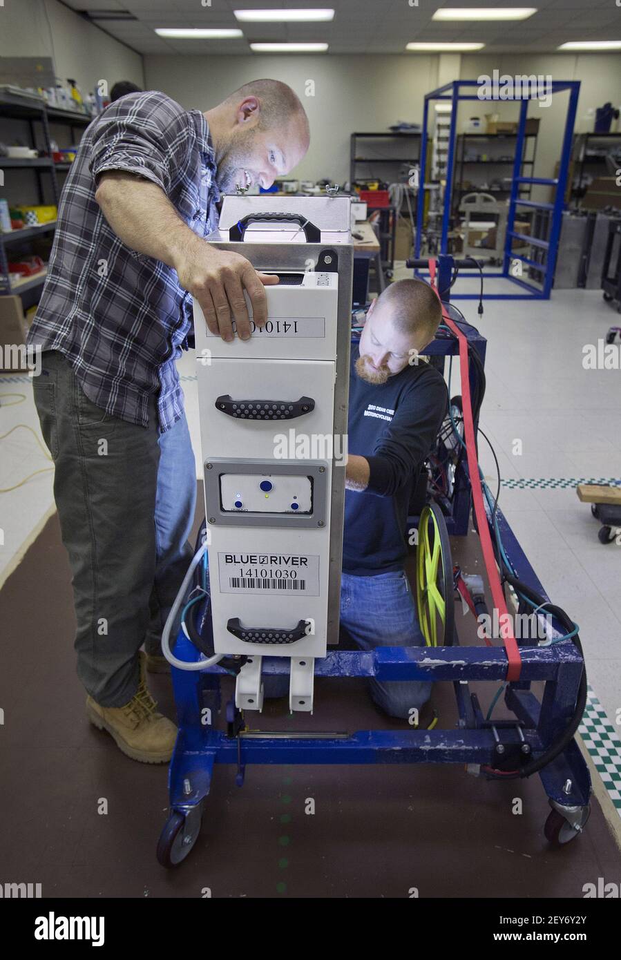 blue-river-technology-software-engineer-willy-pell-left-and-mechanical-engineer-bryon-majusiak-right-repair-the-lighting-system-of-a-seed-line-module-from-a-lettuce-thinning-robot-that-is-about-to