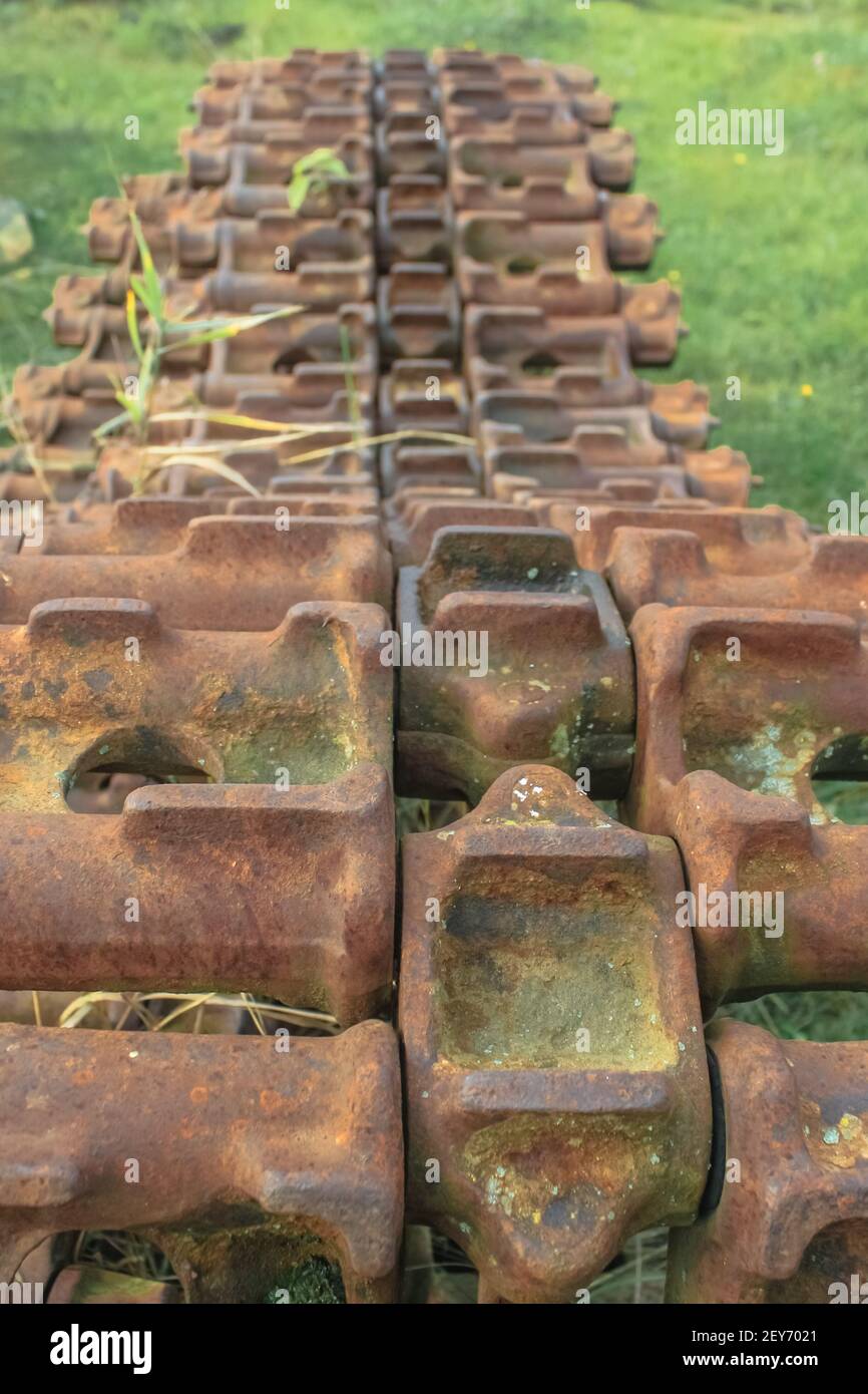 An old rusty track from a tank abandoned in a field. Close-up Stock Photo