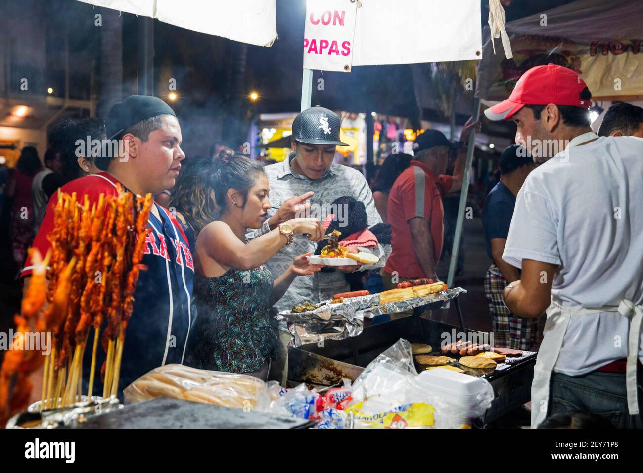 Mexicans buying grilled meat at food stall at the night market along the Malecón, esplanade in the beach resort Puerto Vallarta, Jalisco, Mexico Stock Photo