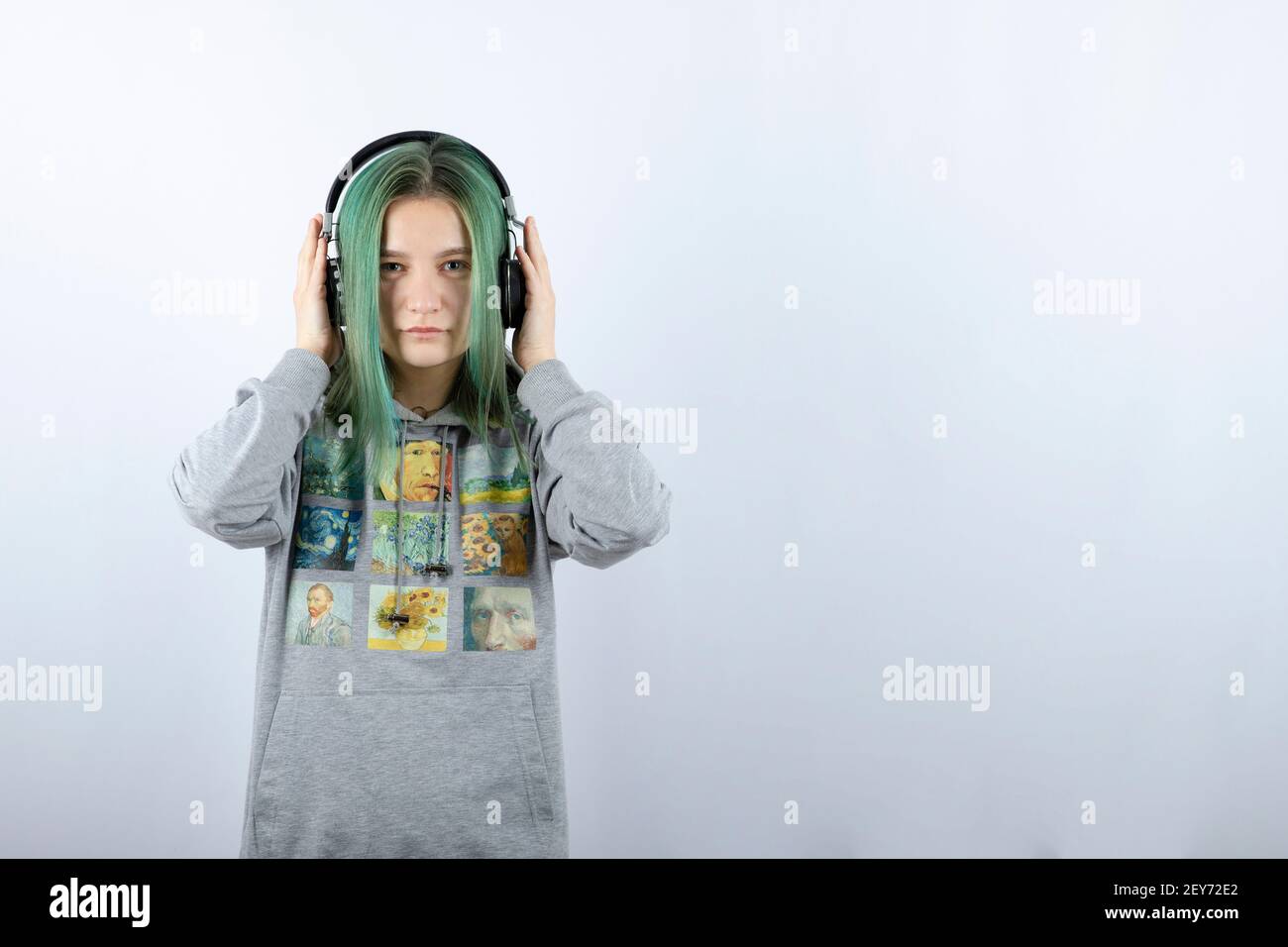 Photo of a young girl with green hair wearing headphones Stock Photo