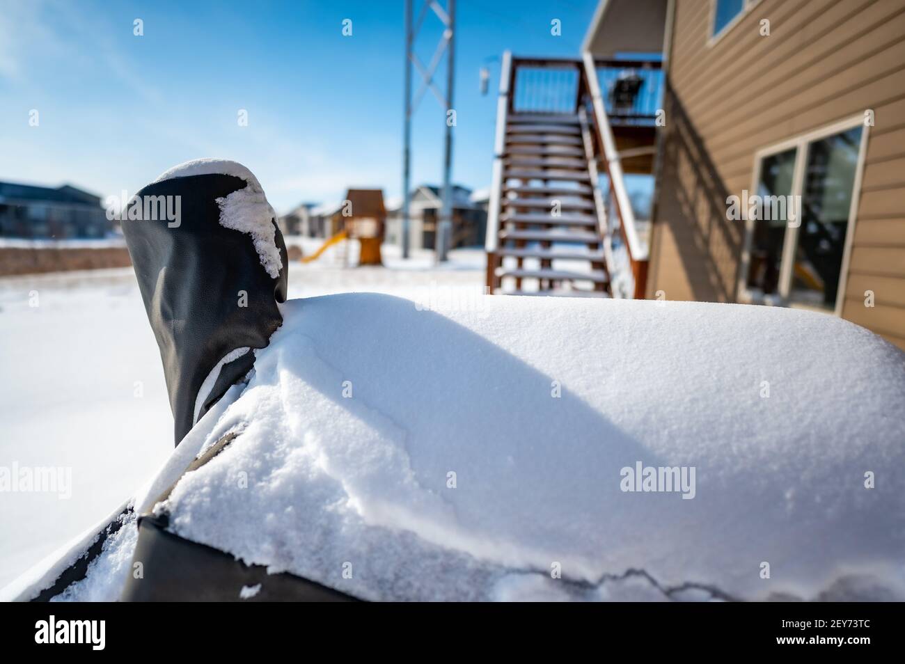 Snow covered BBQ smoker grill in the backyard with winter background
