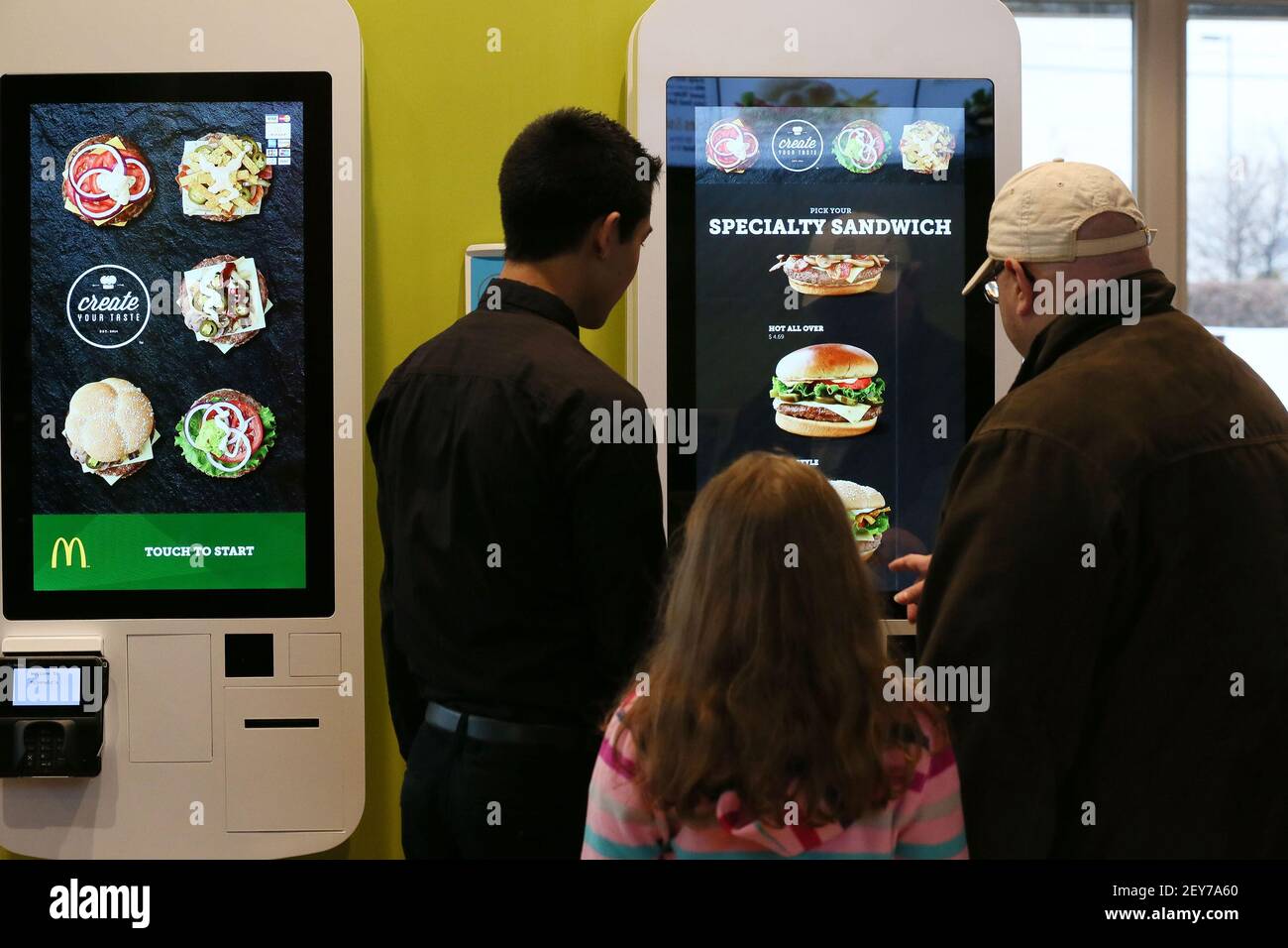 McDonald's worker Sam Shin, left, helps London Cage, right, and his 7 ...