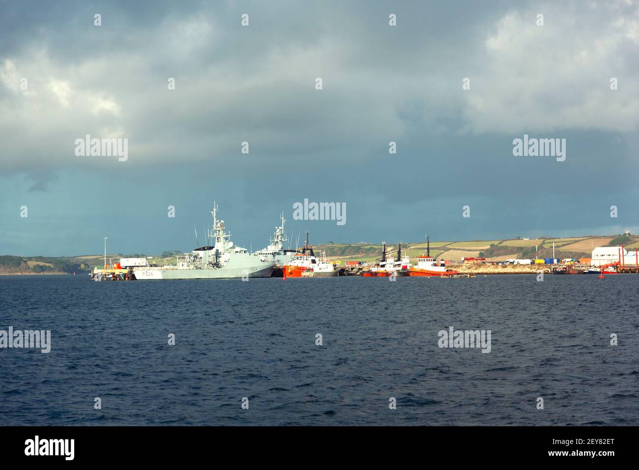 The Royal Navy offshore patrol vessel HMS Trent P224 moored with other vessels and tugs in Falmouth harbour, Cornwall, UK Stock Photo