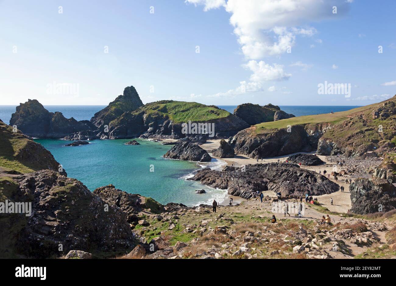 Families enjoying a sunny day in October on the low tide beach at Kynance Cove on the Lizard peninsula in Cornwall ,UK Stock Photo