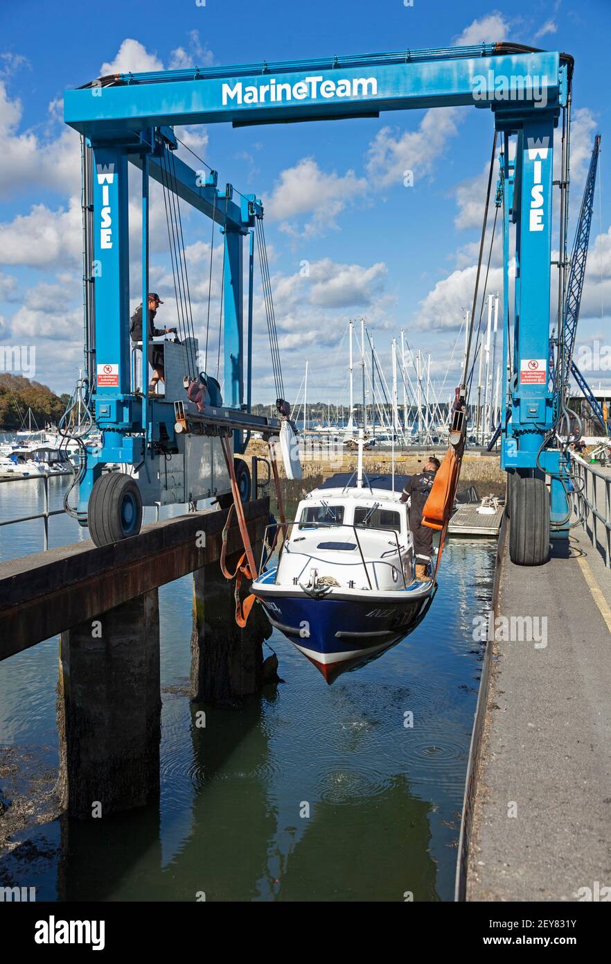 A boat is winched up from the water at Mylor Yatch harbour near Falmouth in Cornwall for maintenance and storage. Stock Photo