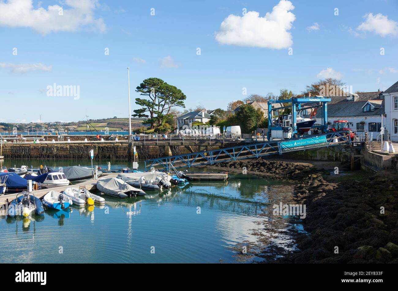 A boat is transported away from the water by tractor to storage at Mylor Yacht Harbour near Falmouth in Cornwall Stock Photo