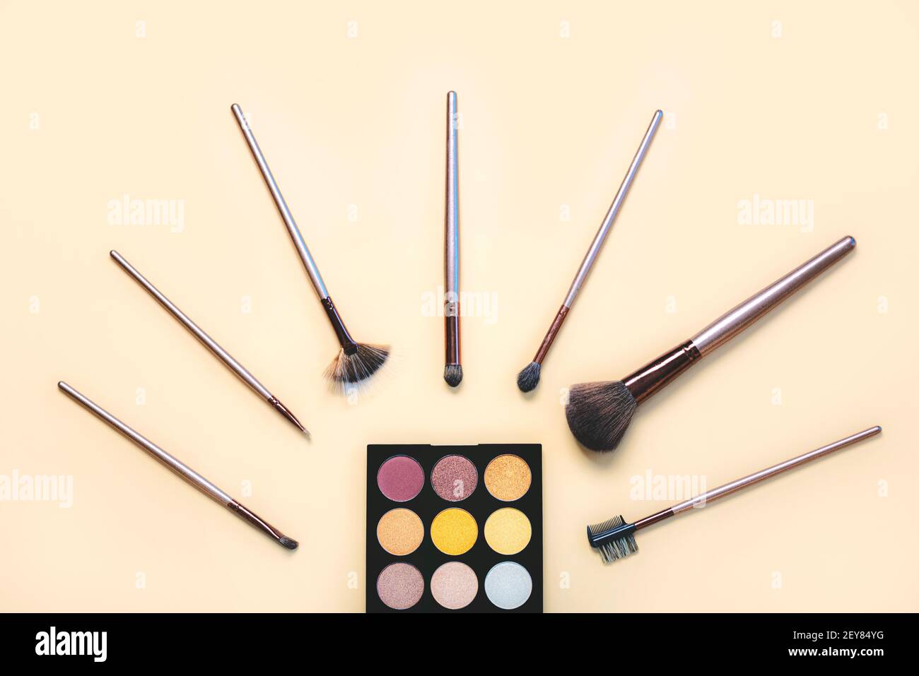 makeup brushes with eyeshadow palette on a beige background.Make Up Beauty Fashion concept Stock Photo