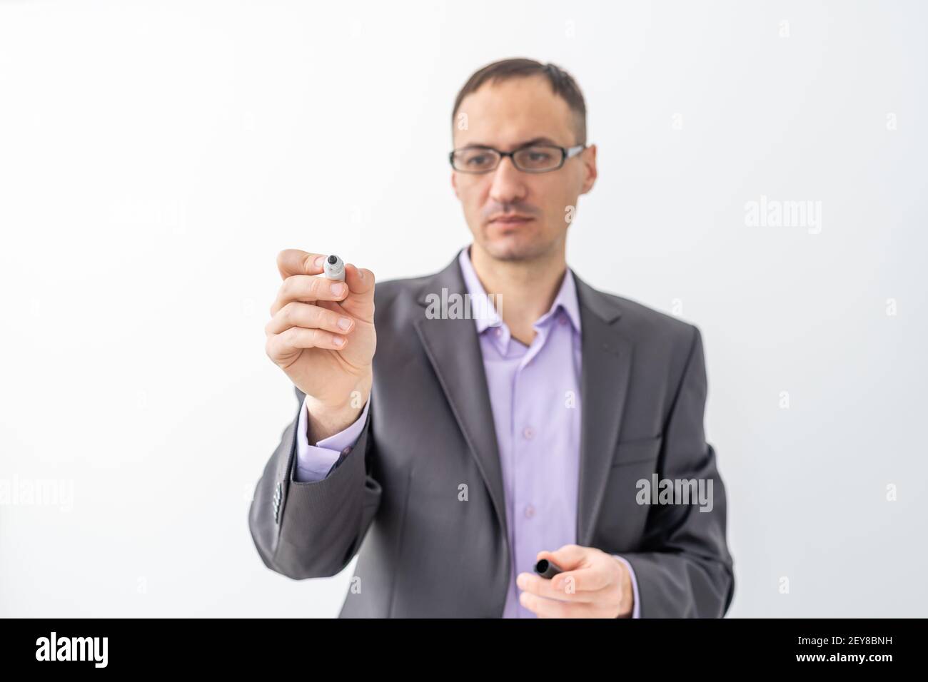 male writing something on glass board with marker Stock Photo