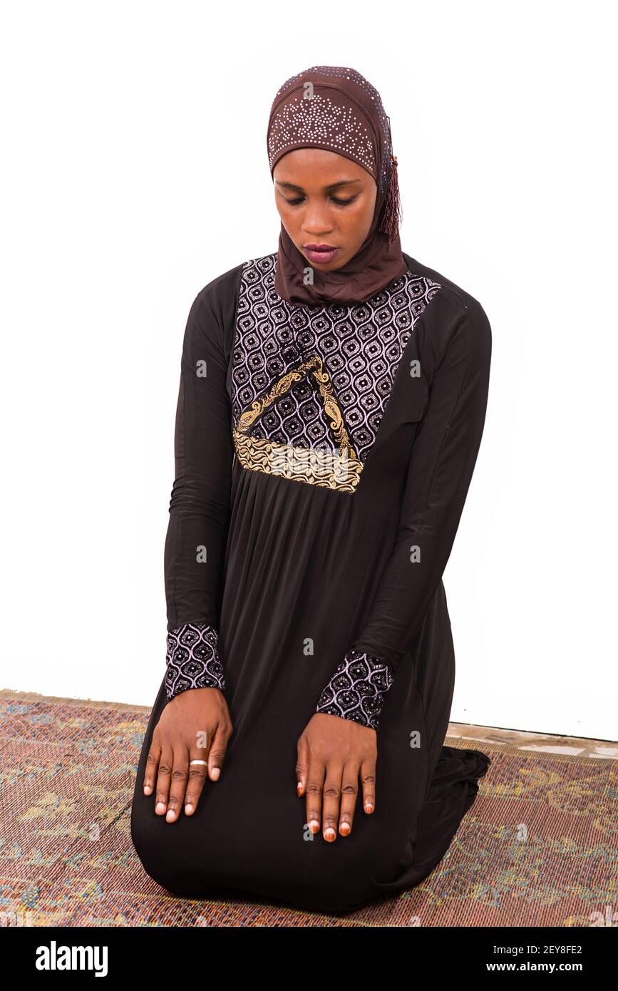young muslim woman kneeling on mat praying Stock Photo - Alamy
