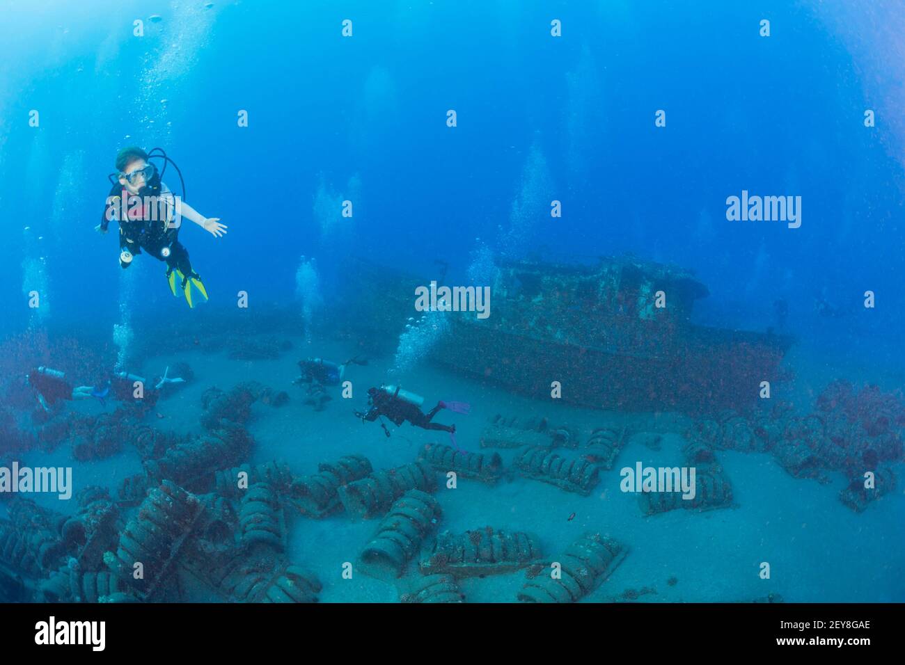 Divers (MR) on the wreck of the St. Anthony off Maui, Hawaii. The tires in concrete around the wreck were an attempt at an artificial reef. Stock Photo