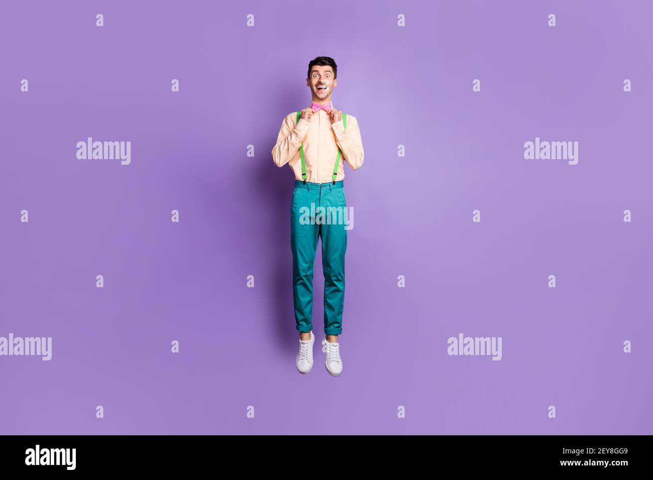 Full body photo of charming handsome man fix adjust pink bow tie jump