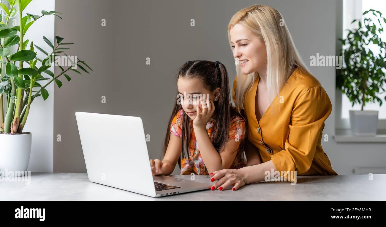 Helpful mother explaining to daughter about using a laptop Stock Photo