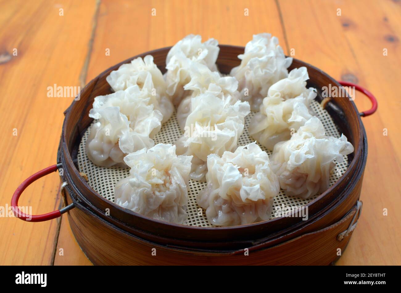 Chinese street food. Steamed siu mai, a type of dim sum made from pork and prawns inside a pastry wrapper. Stock Photo