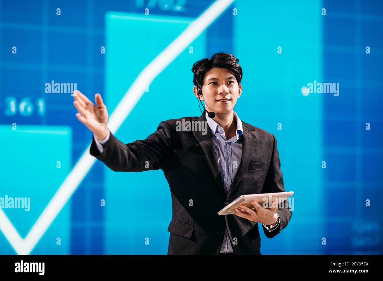 Asian Businessman Stands on Stage for Business Presentation Stock Photo