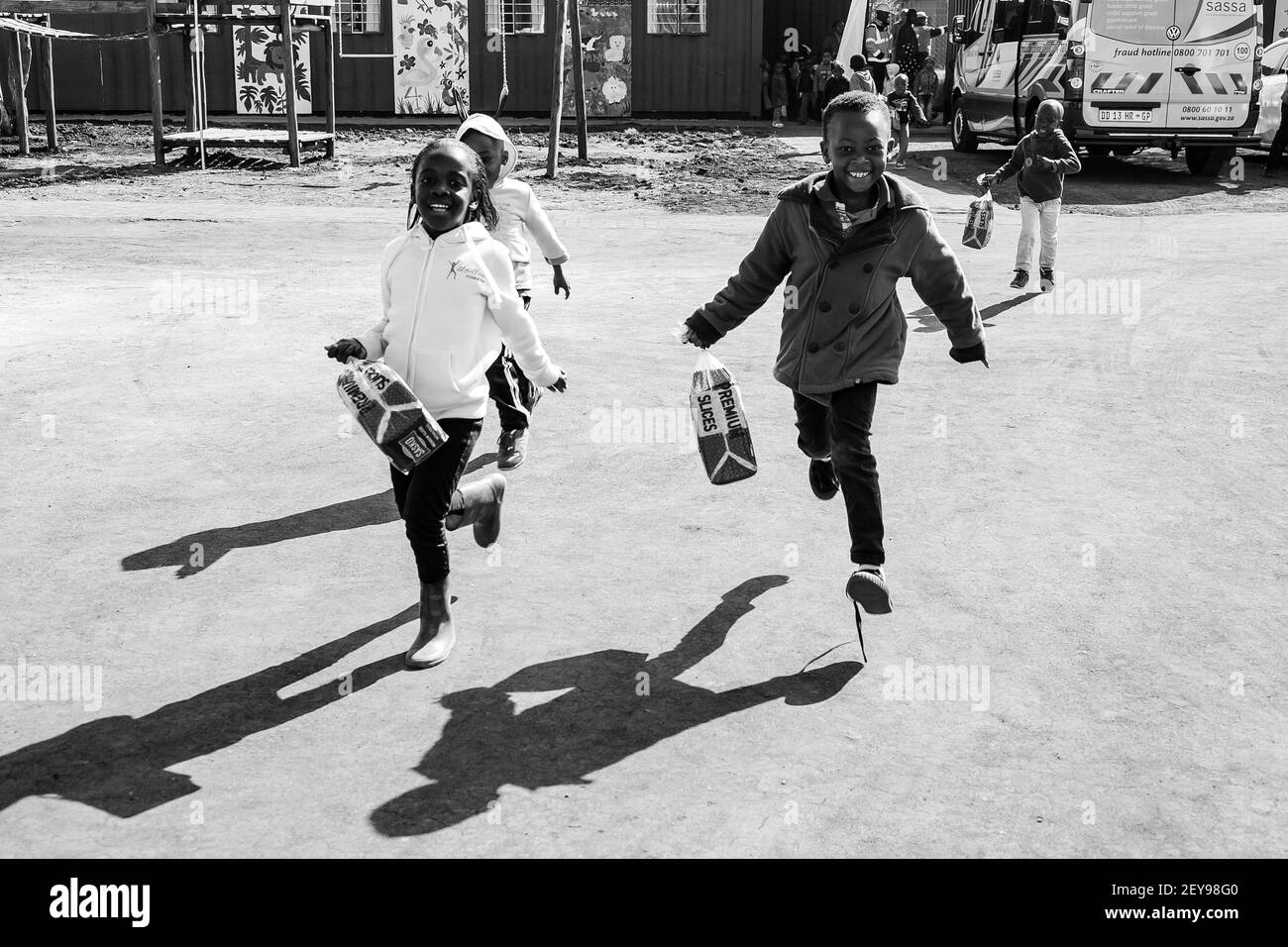 JOHANNESBURG, SOUTH AFRICA - Jan 05, 2021: Soweto, South Africa - July 18, 2016: Young African Preschool kids running with a loaf of bread in the play Stock Photo