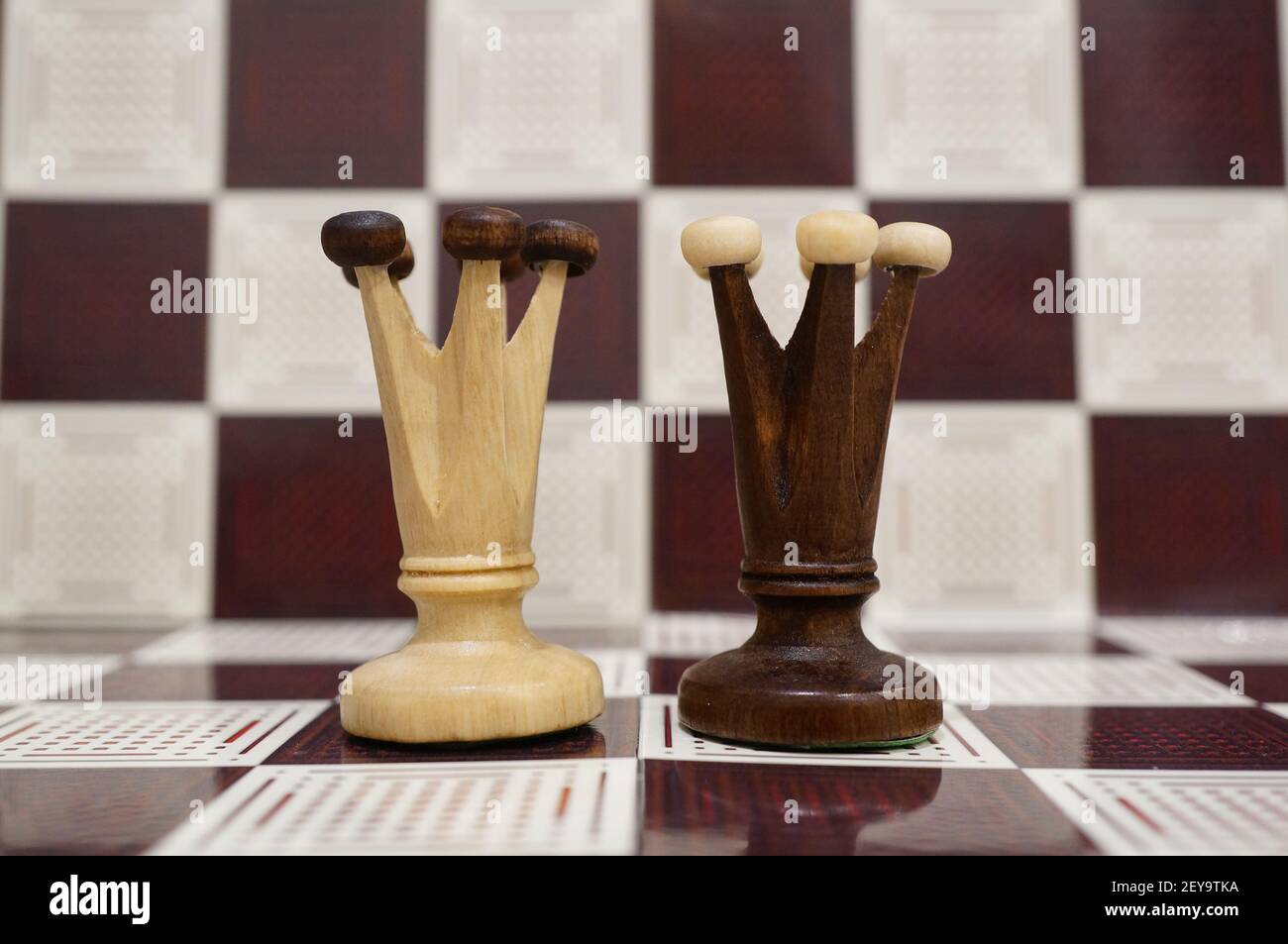 A closeup shot of black and white wooden Queen on the chess board