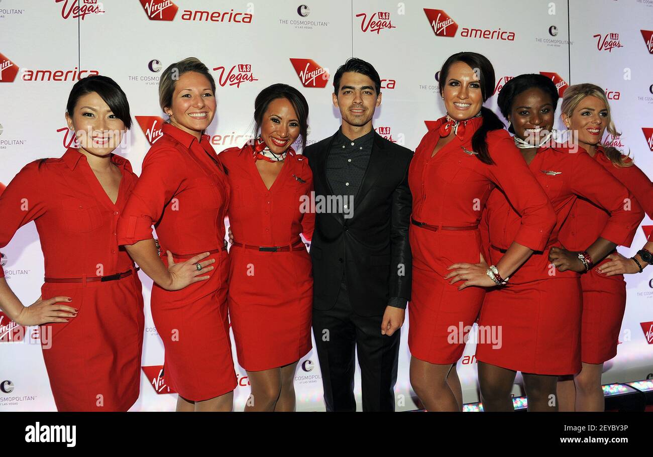 In this photo released by Virgin America Airlines, Joe Jonas (C) is joined by Virgin America teammates on the red carpet during celebration of launch of new nonstop service from Los Angeles International (LAX) to Las Vegas McCarran International (LAS) Airports, Monday, April 22, 2013, inside The Chandelier at The Cosmopolitan of Las Vegas. The airline celebrates its new flight service with a launch party at The Chandelier at The Cosmopolitan of Las Vegas. The new three daily roundtrip flights from LAX to LAS will add to the airline's existing service from San Francisco and New York to Las Vega Stock Photo