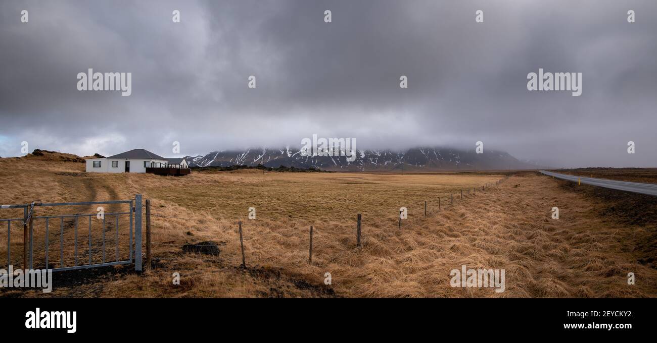 Icelandic landscape at winter. Farmland, farmhouse stormy cloudy sky