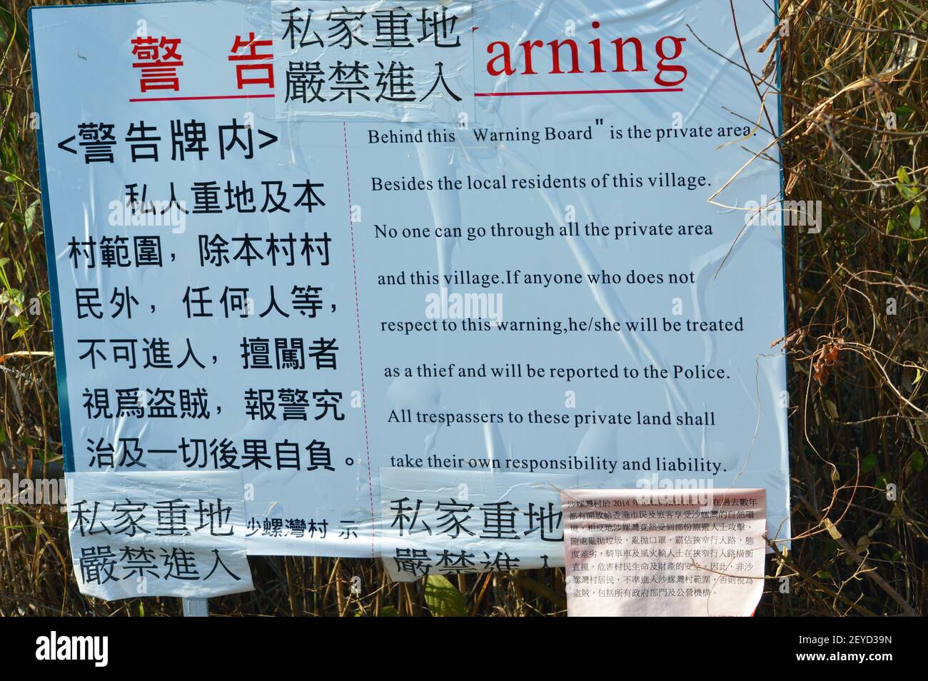 Roadblock warning sign erected by Sha Lo Wan Village (沙螺灣村) villagers who have blocked the path, claiming that the village is a private area. Stock Photo