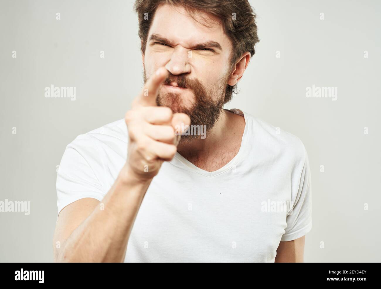 emotional man gesturing with his hands on a light background aggression ...