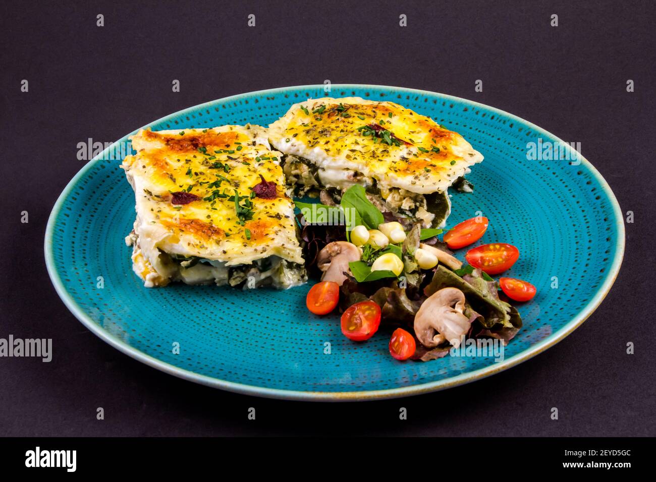 Vegetarian lasagne topped with toasted pine nuts and melting cheeses