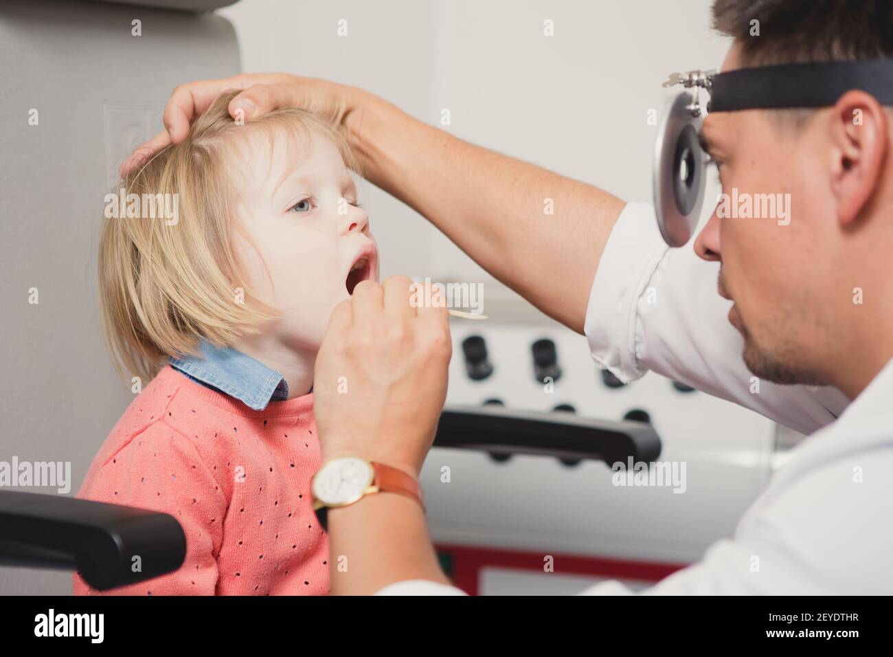 Doctor ENT checking ear with otoscope to girl patient Stock Photo