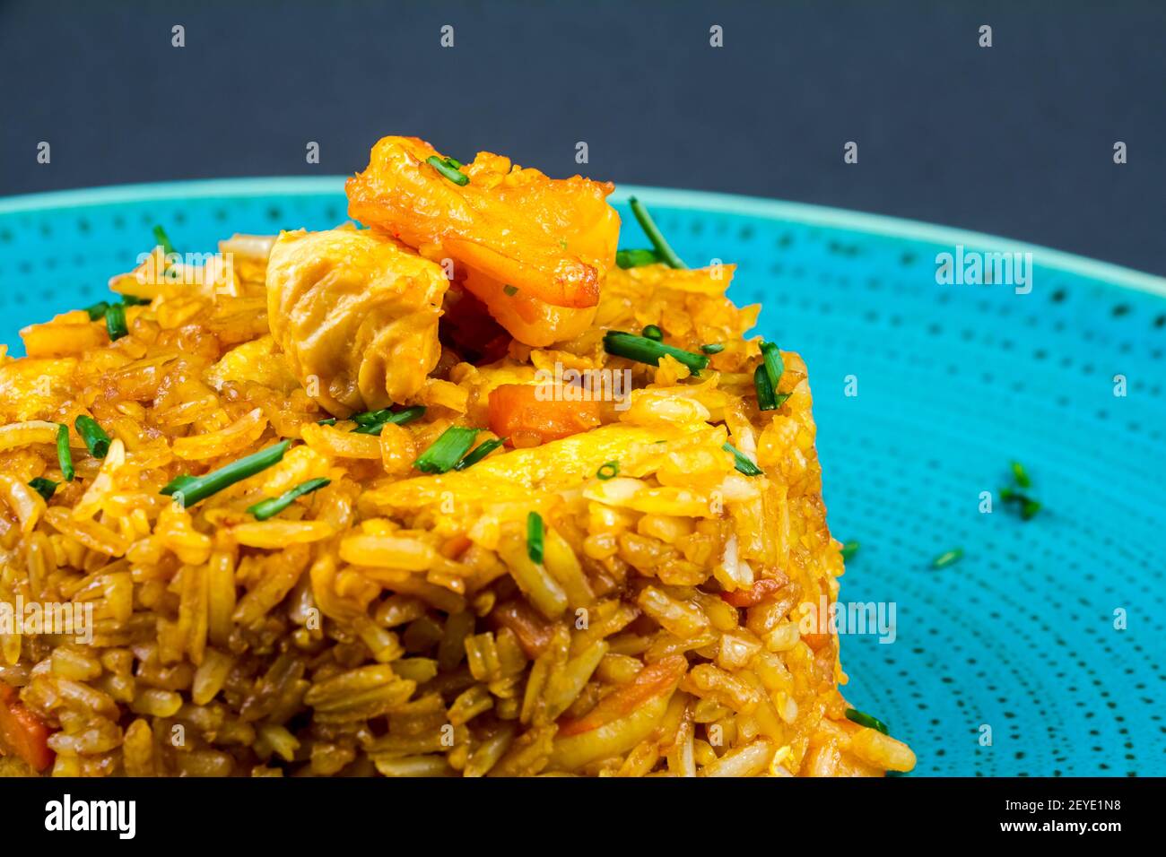 Traditional spanish paella dish with seafood, peas, rice and chicken over grunge blue background. Top view. Selective focus Stock Photo