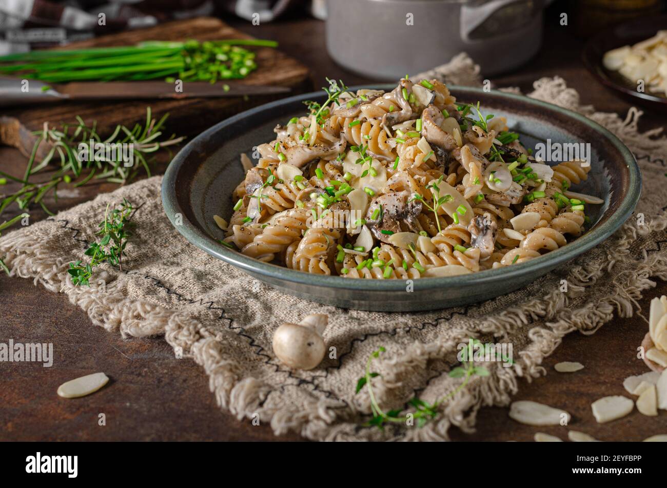 Original creamy pasta with mushrooms, herbs and almond slices Stock Photo