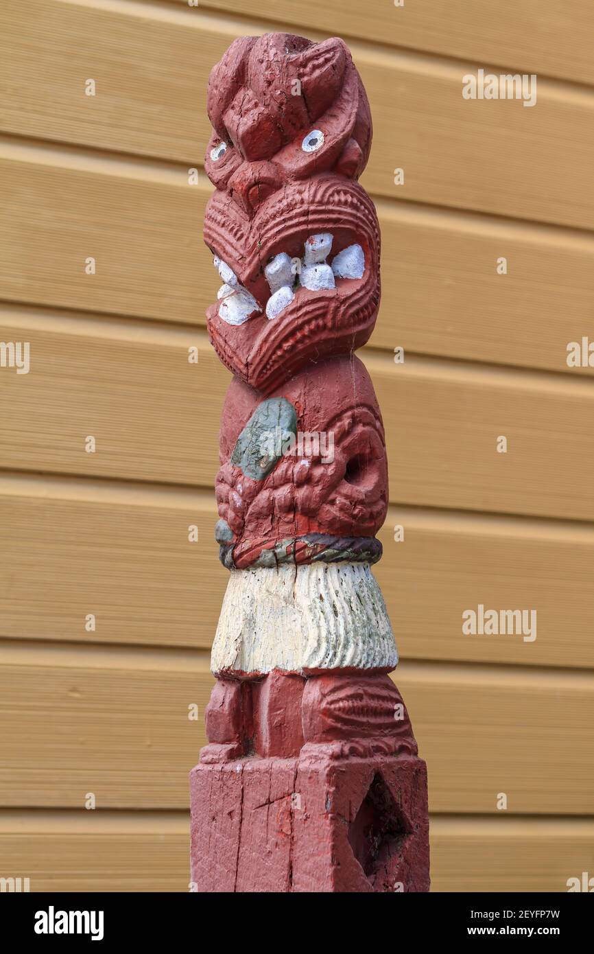 A New Zealand Maori wood carving depicting the stylized figure of a warrior holding a greenstone club Stock Photo