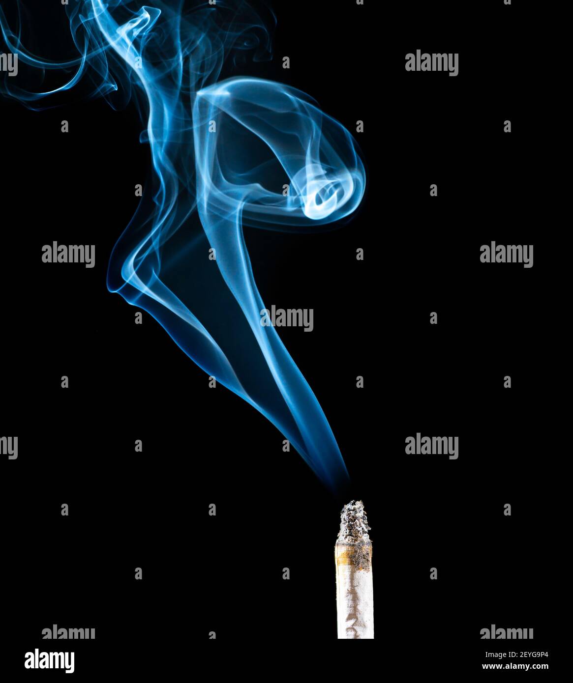 Close-up of backlit smoke cloud coming from a cigarette against black background. Stock Photo