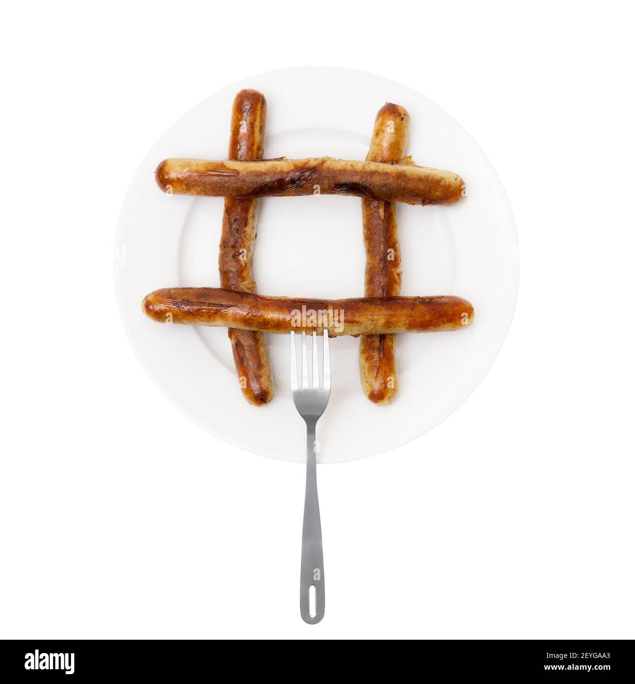 Close-up of a hash symbol made of traditional grilled german sausages on a large white plate with a fork isolated on a white background. Stock Photo
