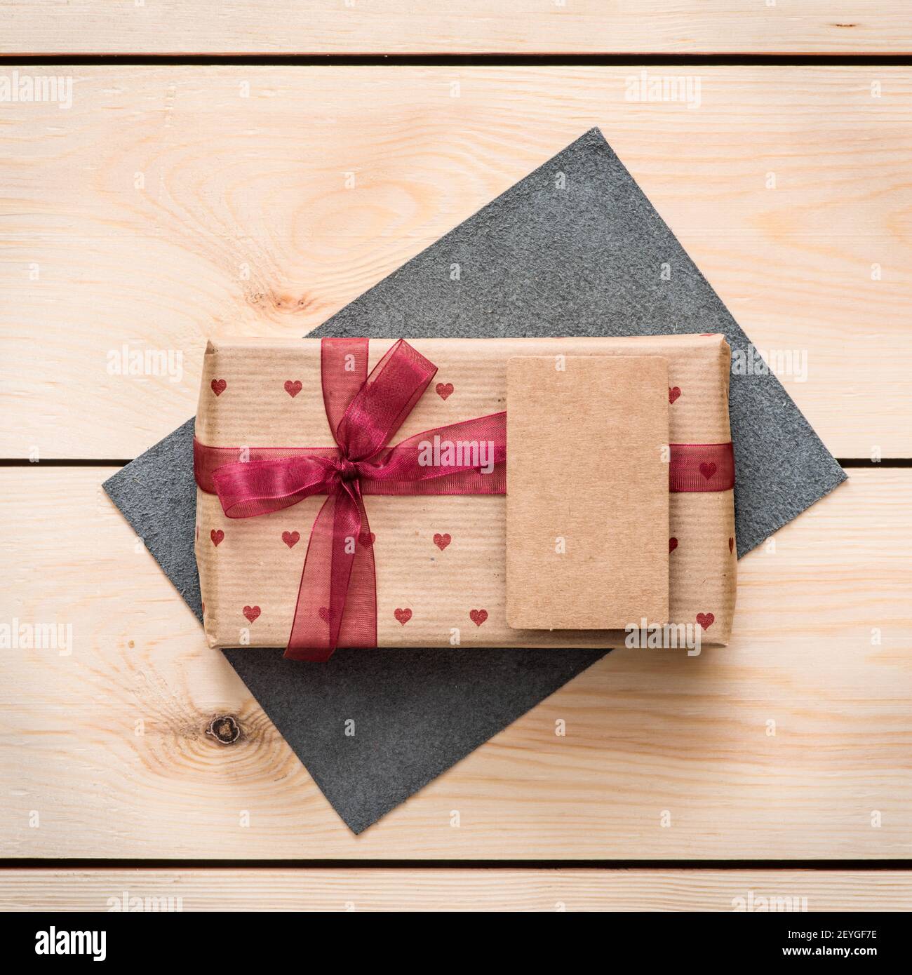 Gift box with white blank tag and hearts. Stock Photo