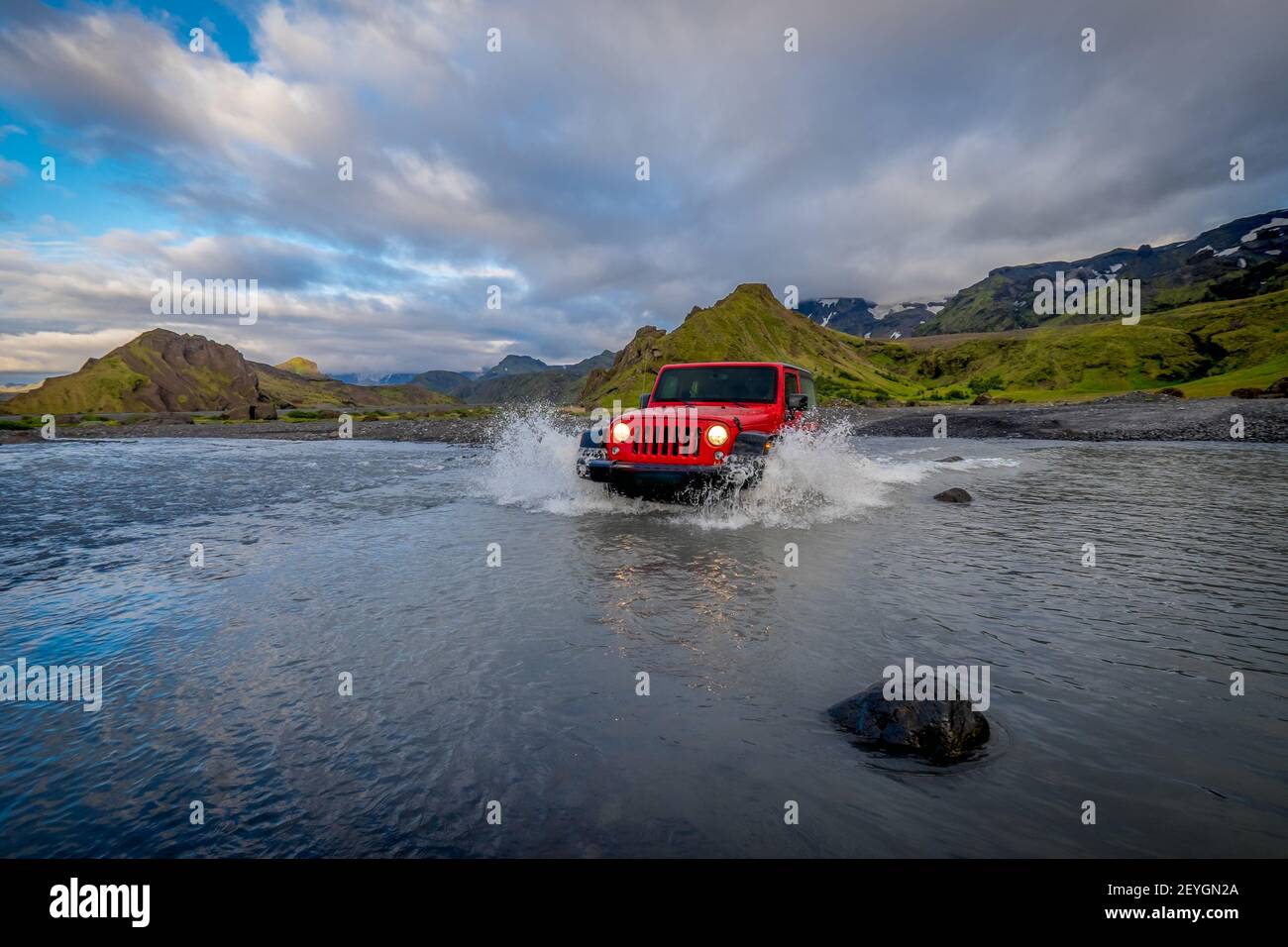A red racing car driving through the river and making splashes Stock ...