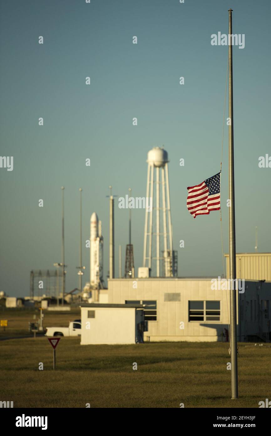 A United States flag is flown at half-staff just outside the Mid-Atlantic Regional Spaceport (MARS) Pad-0A with the Orbital Sciences Corporation Antares rocket, Tuesday, Sept. 17, 2013, NASA Wallops Flight Facility, Virginia. President Obama directed Monday that flags be lowered to half-staff to pay tribute to the victims of 'the senseless acts of violence' perpetrated at the Washington Navy Yard. NASA's commercial space partner, Orbital Sciences Corporation, is targeting a Sept. 18 launch of the Cygnus cargo spacecraft, demonstration cargo resupply mission, to the International Space Station. Stock Photo