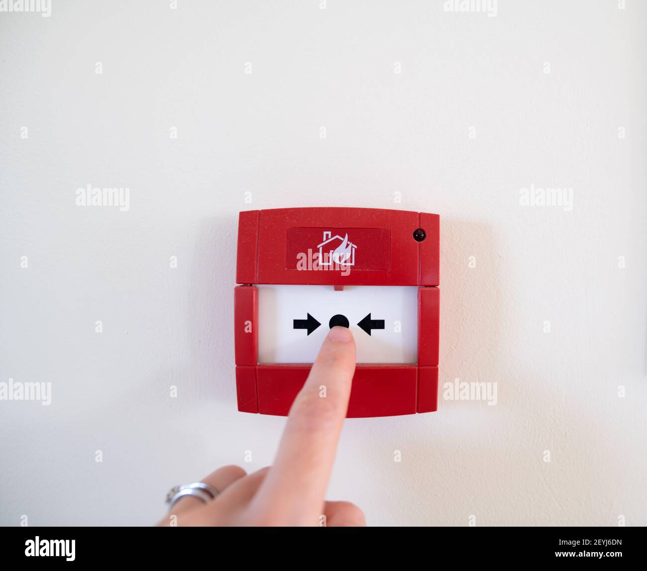 Finger ready to press a fire alarm button Stock Photo