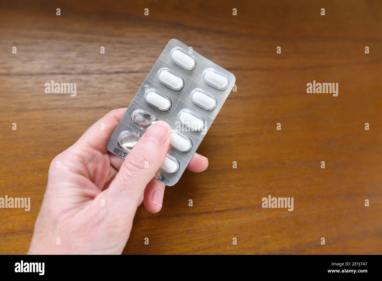 Hand holding a packet of white pills Stock Photo